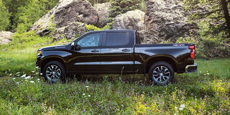 Chevrolet Silverado 1500 with large rocks in the background, highlighting its durability.